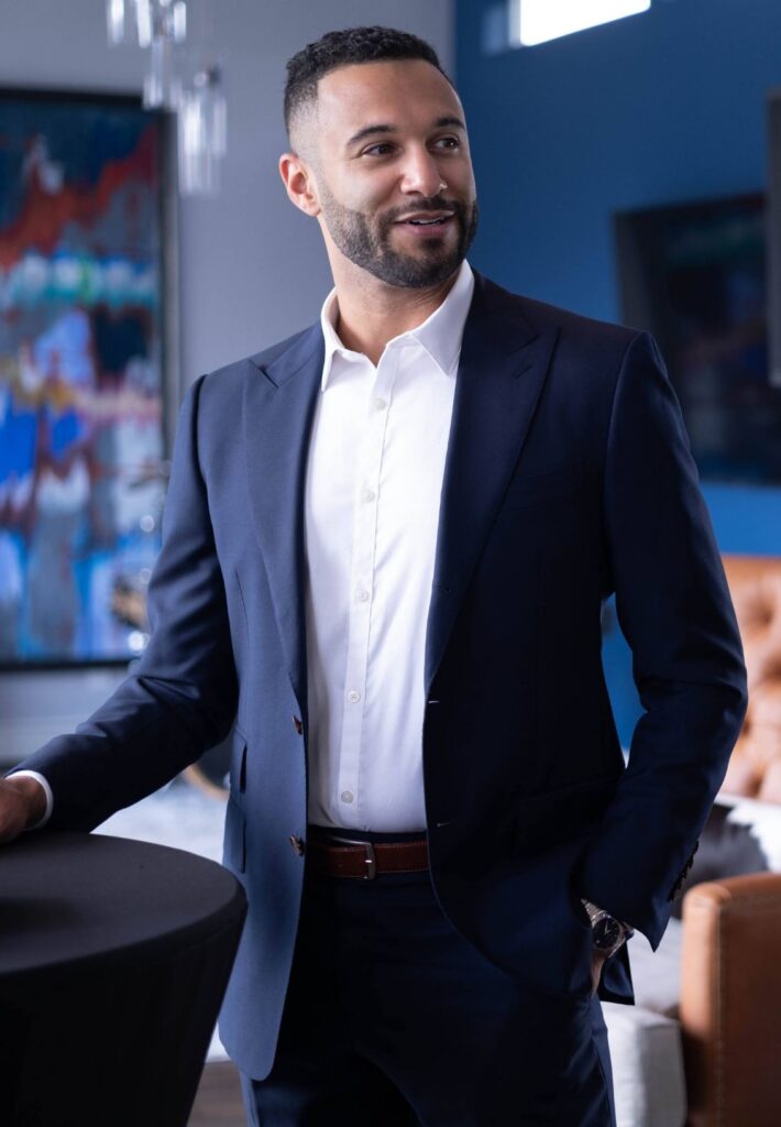 Coaching business launchpad founder and lead coach, John Marshall, wearing a suite, looking off to the side.
